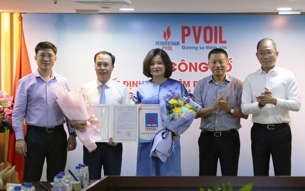 Ông Phan Anh Minh – Ủy viên BTV Đảng ủy, Trưởng ban Quản trị nguồn nhân lực Tập đoàn Dầu khí Việt Nam (bên trái); ông Cao Hoài Dương – Chủ tịch HĐQT PVOIL (bên phải); ông Đoàn Văn Nhuộm – Tổng Giám đốc PVOIL (thứ hai, bên phải) trao Quyết định và tặng hoa chúc mừng ông Hoàng Đình Tùng và bà Lê Thị Thu Hương.