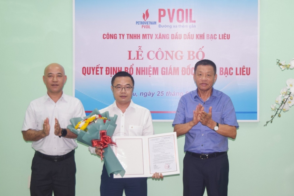 Ông Đoàn Văn Nhuộm – Phó Bí thư Đảng ủy, Tổng Giám đốc PVOIL (bên phải) và ông Nguyễn Ngọc Ninh – Kế toán Trưởng PVOIL (bên trái) trao Quyết định và tặng hoa chúc mừng ông Nguyễn Hữu Thuật