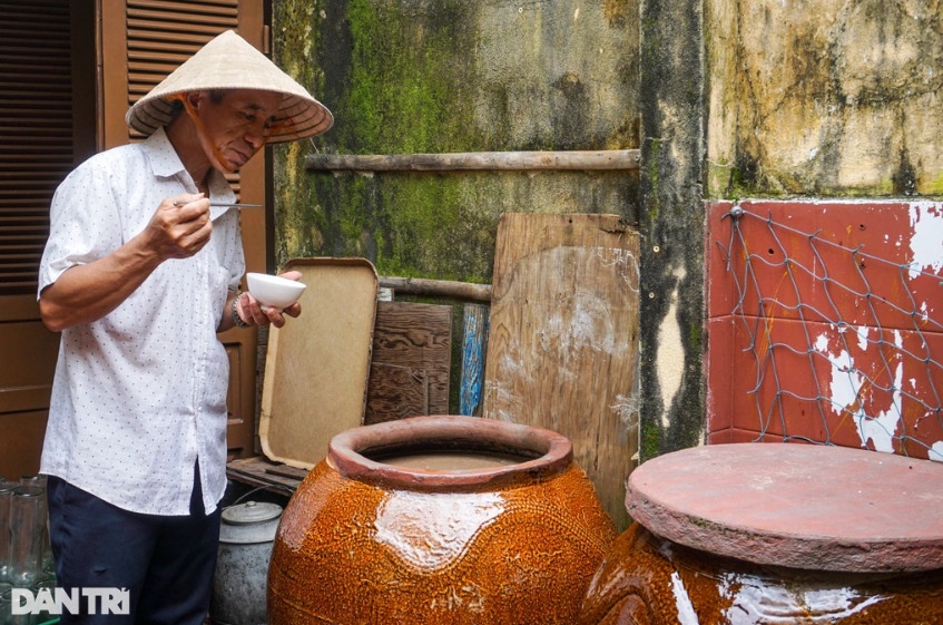 Ông Mười dùng chiếc đũa để nếm mắm, mắm có hương vị đạt được cho vào một chum khác để chiết xuất (Ảnh: Hoài Sơn).