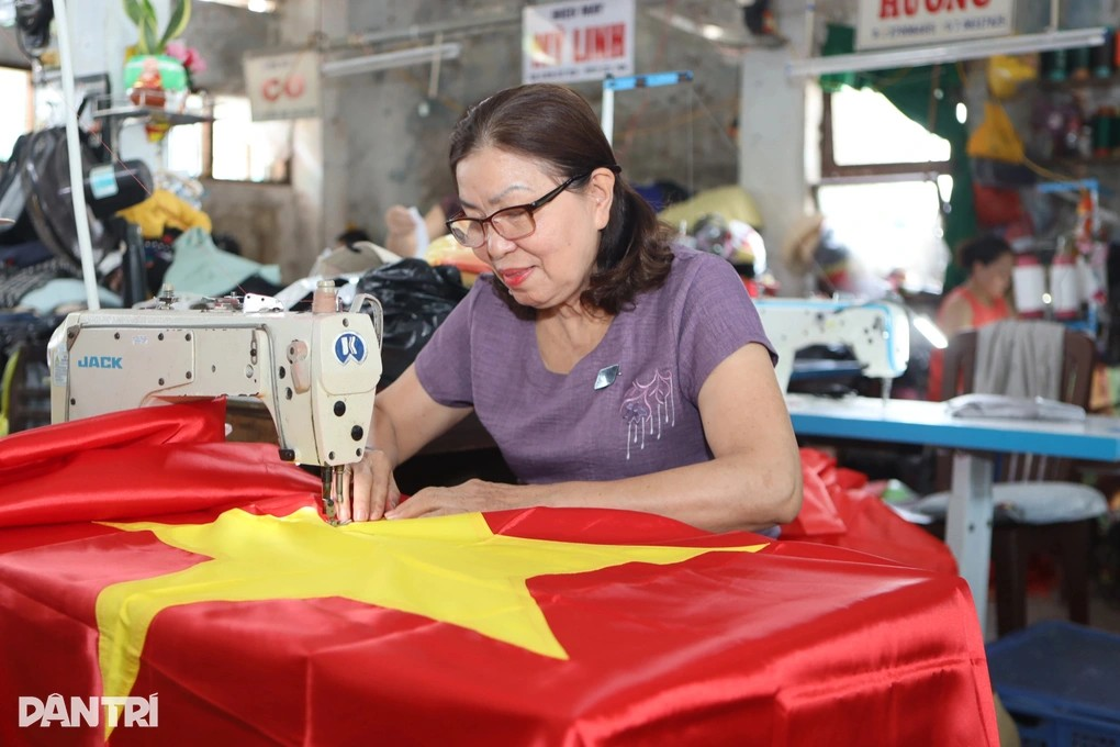 Người phụ nữ đã gắn bó với công việc may cờ treo ở Kỳ đài Huế suốt 15 năm trở lại đây (Ảnh: Vi Thảo).