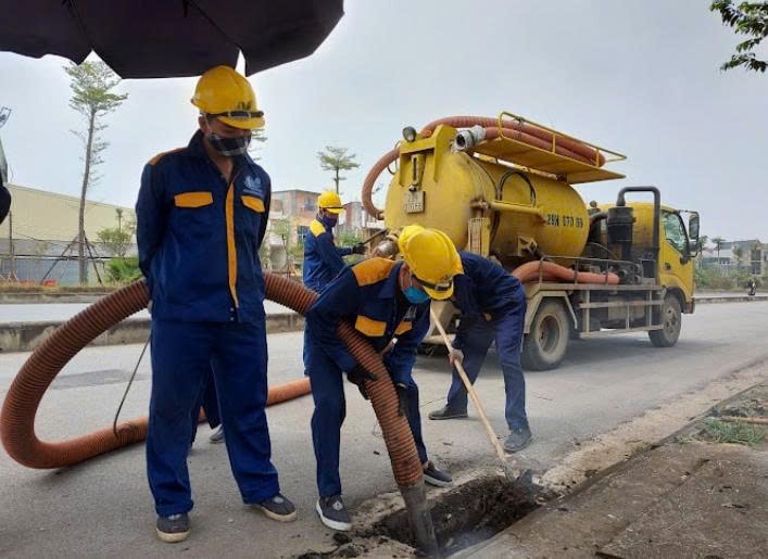 Công nhân Công ty TNHH một thành viên Thoát nước Hà Nội chủ động khơi thông hệ thống tiêu thoát, đề phòng ngập lụt đường phố, khu dân cư. Ảnh: Kim Nhuệ