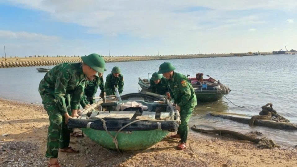 Cán bộ, chiến sĩ Đồn Biên phòng Bạch Long Vĩ giúp ngư dân kéo phương tiện lên bờ để tránh, trú bão. Ảnh: Xuân Chính