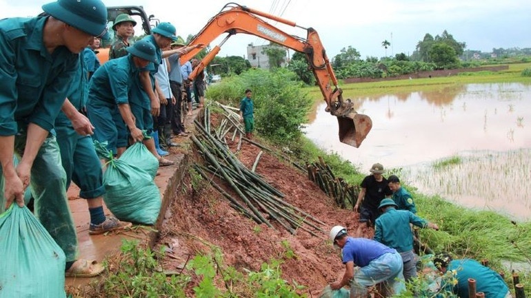 Lực lượng chức năng, người dân chung sức khắc phục sự cố sạt lở đê tả sông Thương.