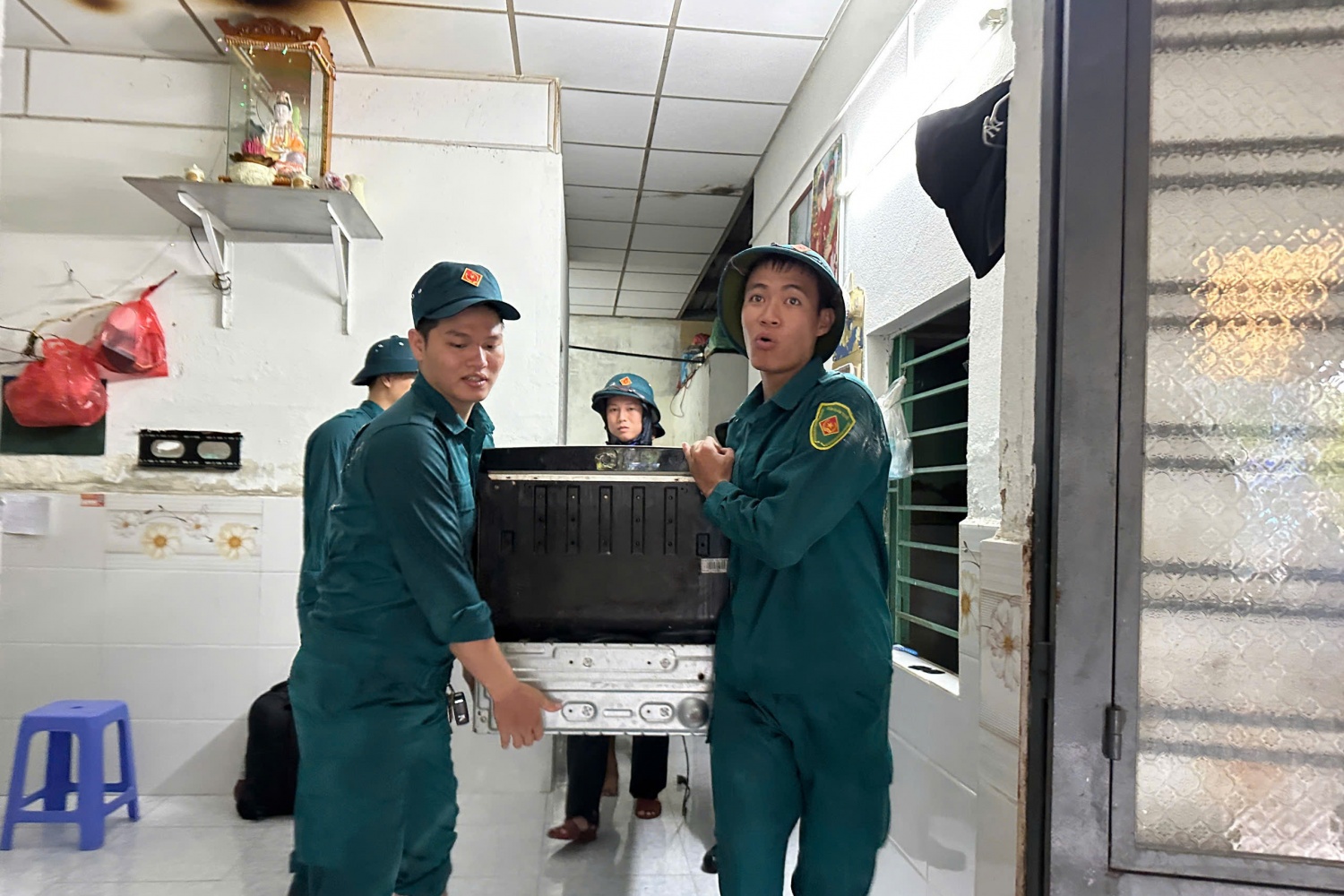 Lực lượng dân quân khu vực hỗ trợ người dân đưa các vật dụng có giá trị đến nơi an toàn