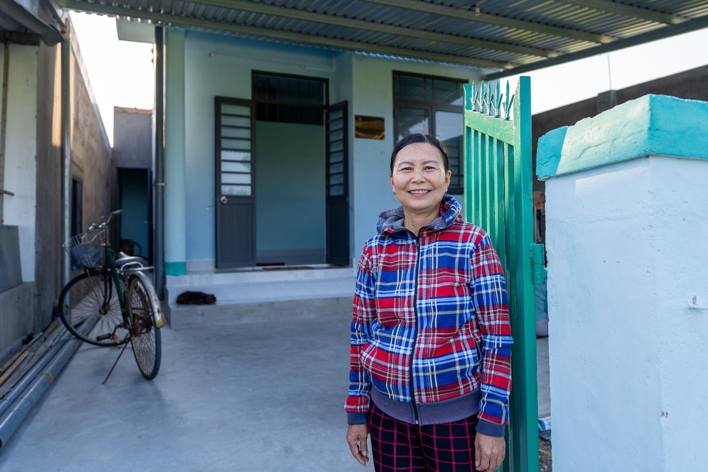 Bà Võ Thị Siêng vui mừng bên căn nhà mới. Bà Võ Thị Siêng vui mừng bên căn nhà mới.