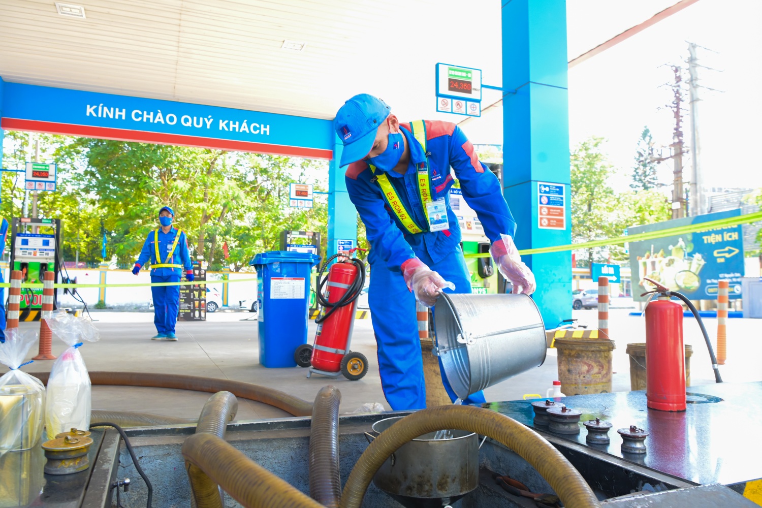 Nhân viên cửa hàng xăng dầu thực hiện công đoạn lấy mẫu và kiểm tra nhiên liệu trong quá trình nhập xăng sinh học E10 vào bể chứa tại hệ thống PVOIL.