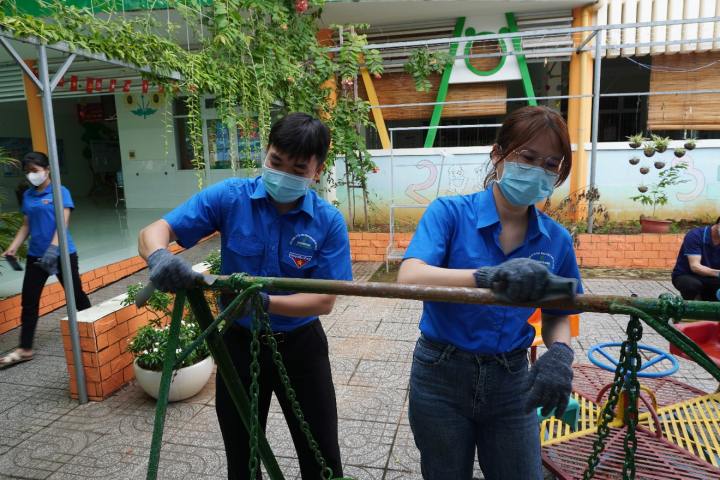 Lực lượng tình nguyện viên dọn dẹp, chỉnh trang khuôn viên Trường Tiểu học Long Sơn 1.