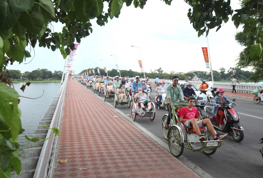 Trong tháng 7, lượng khách du lịch đến Thừa Thiên Huế ước đạt trên 290 nghìn lượt, tăng 3,58%; trong đó khách quốc tế ước đạt trên 87 nghìn lượt, tăng 4,23%; khách nội địa gần 203 nghìn lượt, tăng 2,93%. Khách lưu trú ước đạt trên 176 nghìn lượt, trong đó khách quốc tế hơn 62 nghìn lượt, tăng 3,65%. Doanh thu từ du lịch ước đạt 251,860 tỷ đồng, tăng 2,42% so với cùng kỳ. Lượng khách du lịch đến Thừa Thiên Huế trong 7 tháng đầu năm đạt hơn 1.874.600 lượt, tăng 4,6%. Doanh thu du lịch 7 tháng ước đạt 1.652,815 tỷ đồng, tăng 5,14% so với cùng kỳ. Trong ảnh: Khách quốc tế du lịch TP Huế bằng xích lô. Ảnh: Anh Tuấn - TTXVN