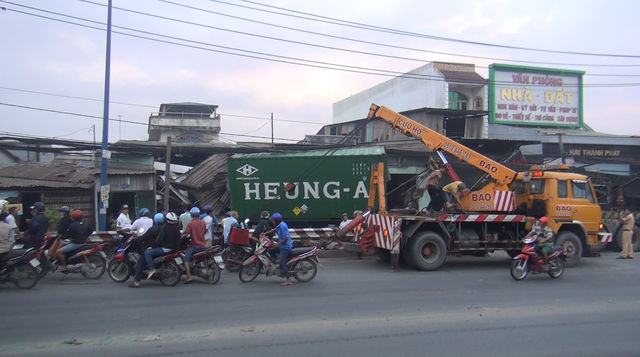 tranh nguoi sang duong xe container tong sap hang loat nha dan