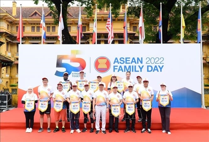 Bộ trưởng Bộ Ngoại giao Bùi Thanh Sơn trao cờ lưu niệm cho đại diện các nước ASEAN tại Hà Nội và các nước Đối tác của ASEAN cùng các thành viên Gia đình ASEAN. Ảnh:  TTXVN 