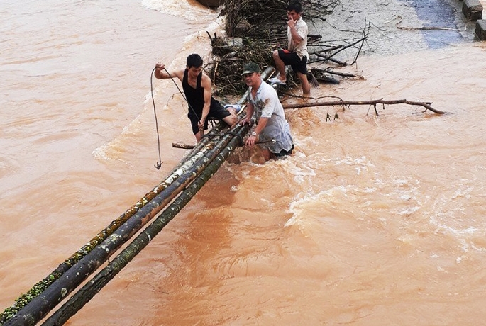 Người dân bắc cây cau qua nhịp cầu gãy để vượt lũ