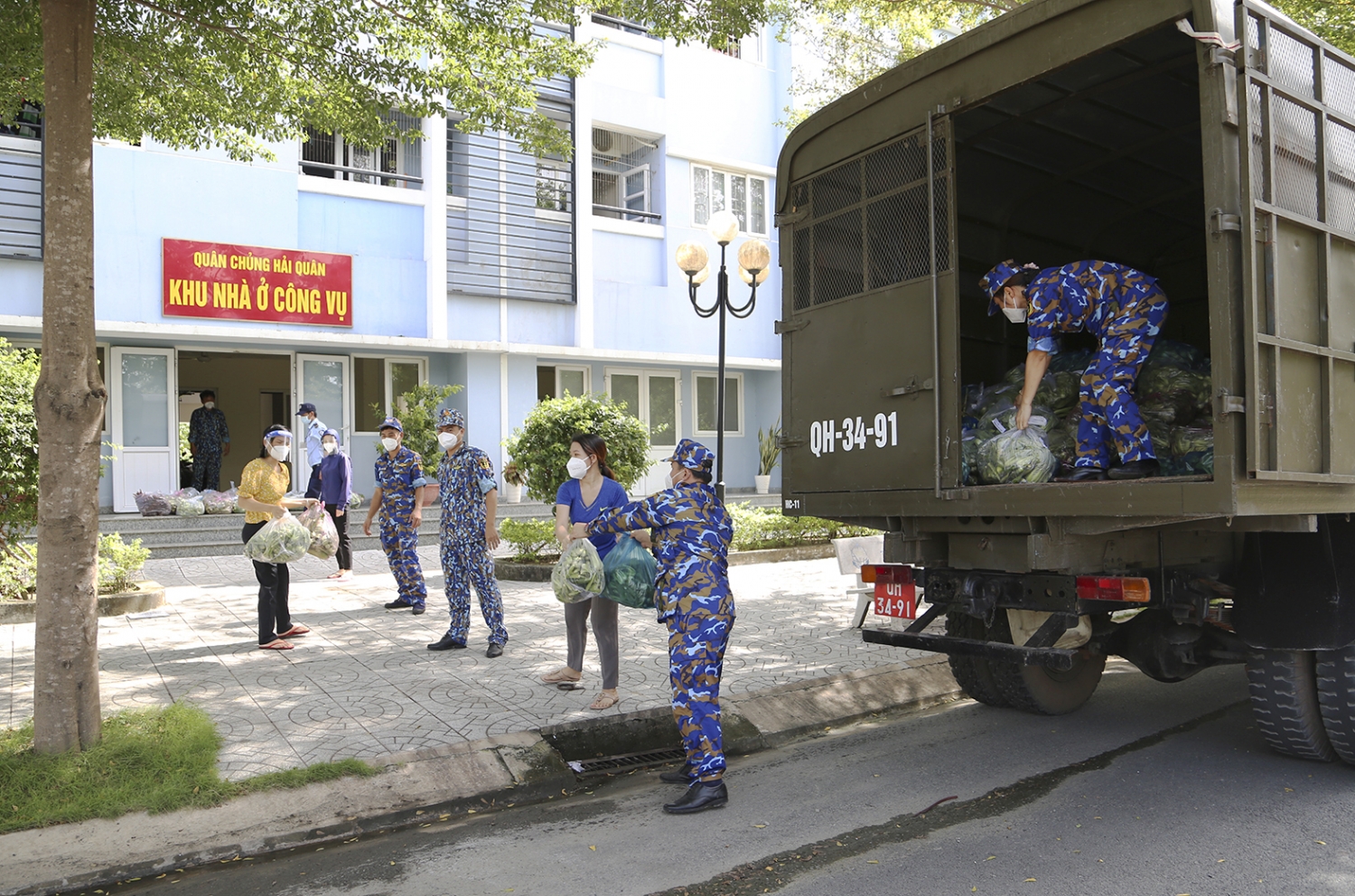Cán bộ, nhân viên Kho 711 chuyển rau xanh từ xe xuống các điểm tập kết